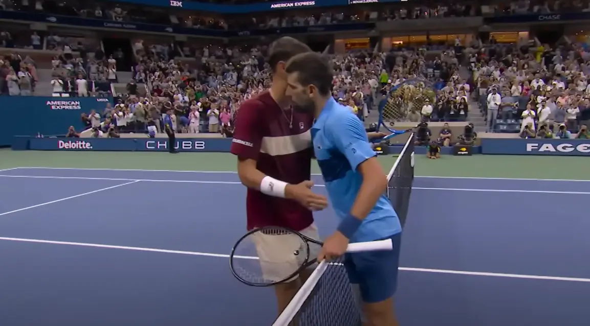 Novak Djokovic and Alexei Popyrin exchange words and shake hands after their match at the US Open.